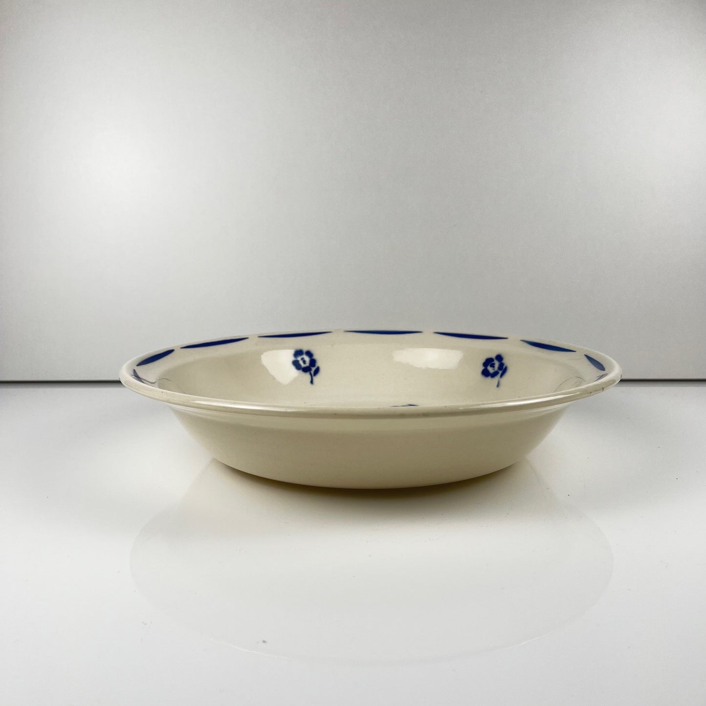 Saladier bas Demi-porcelaine Badonviller, motif fleurs bleu, début XXe