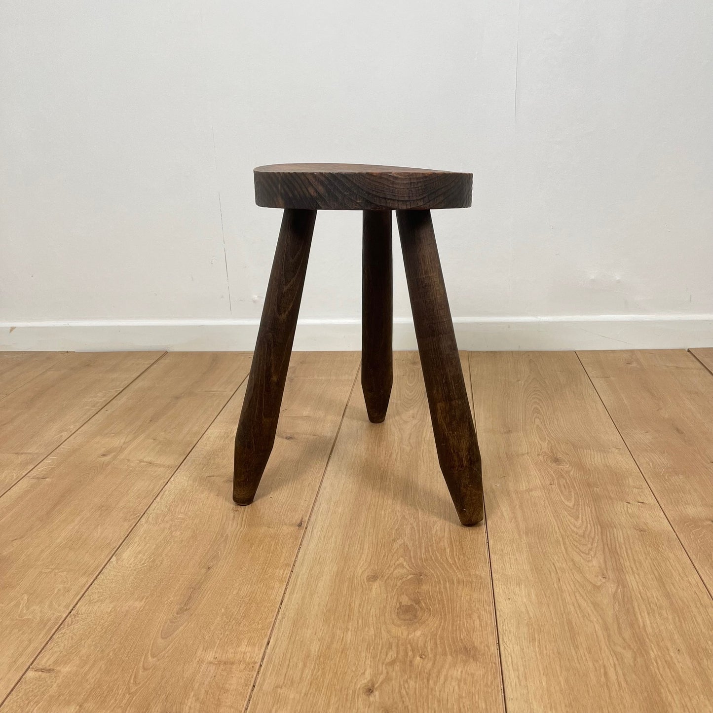 Petit tabouret tripode brutaliste en bois massif
