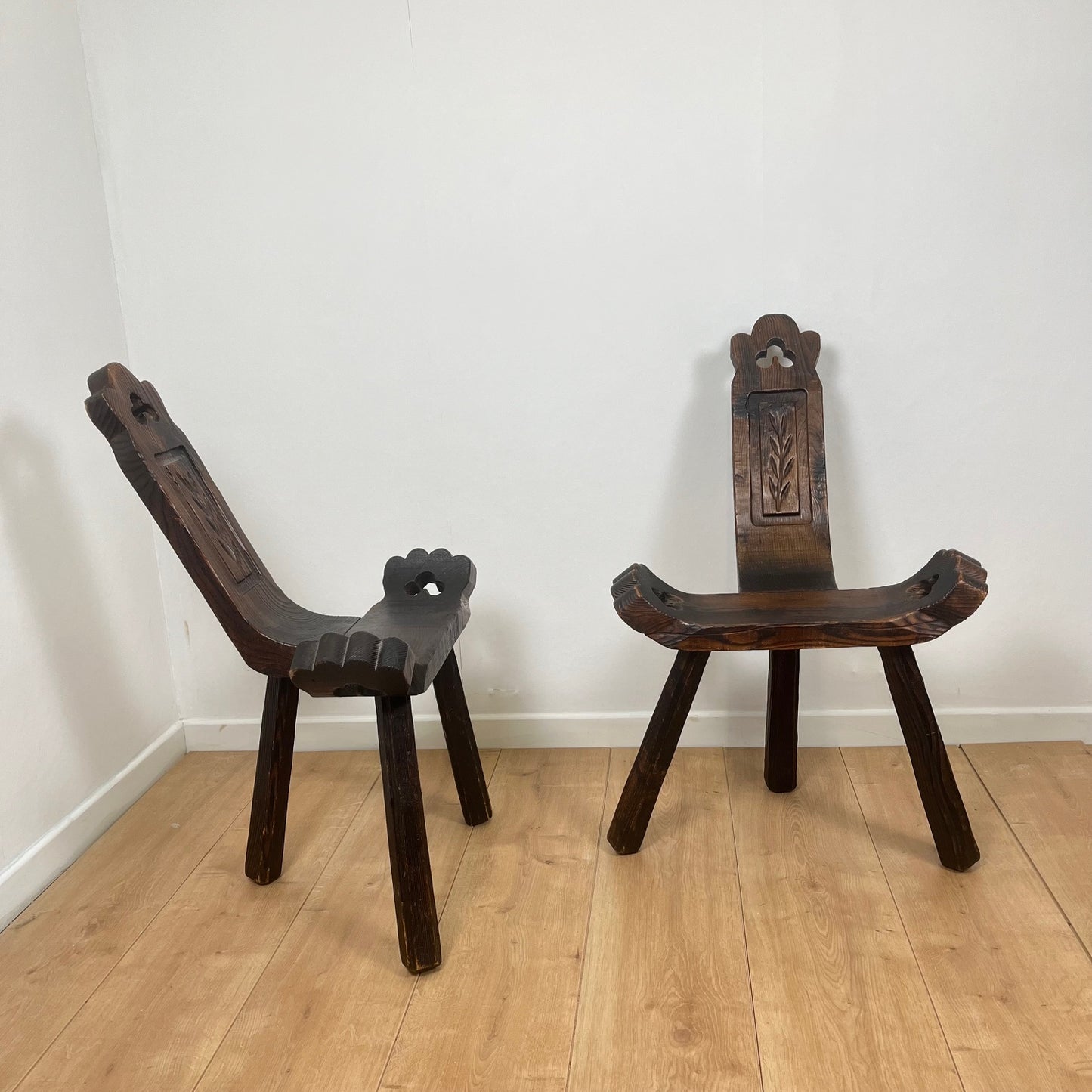 Pair of brutalist tripod low chairs in solid wood, mid-20th century.