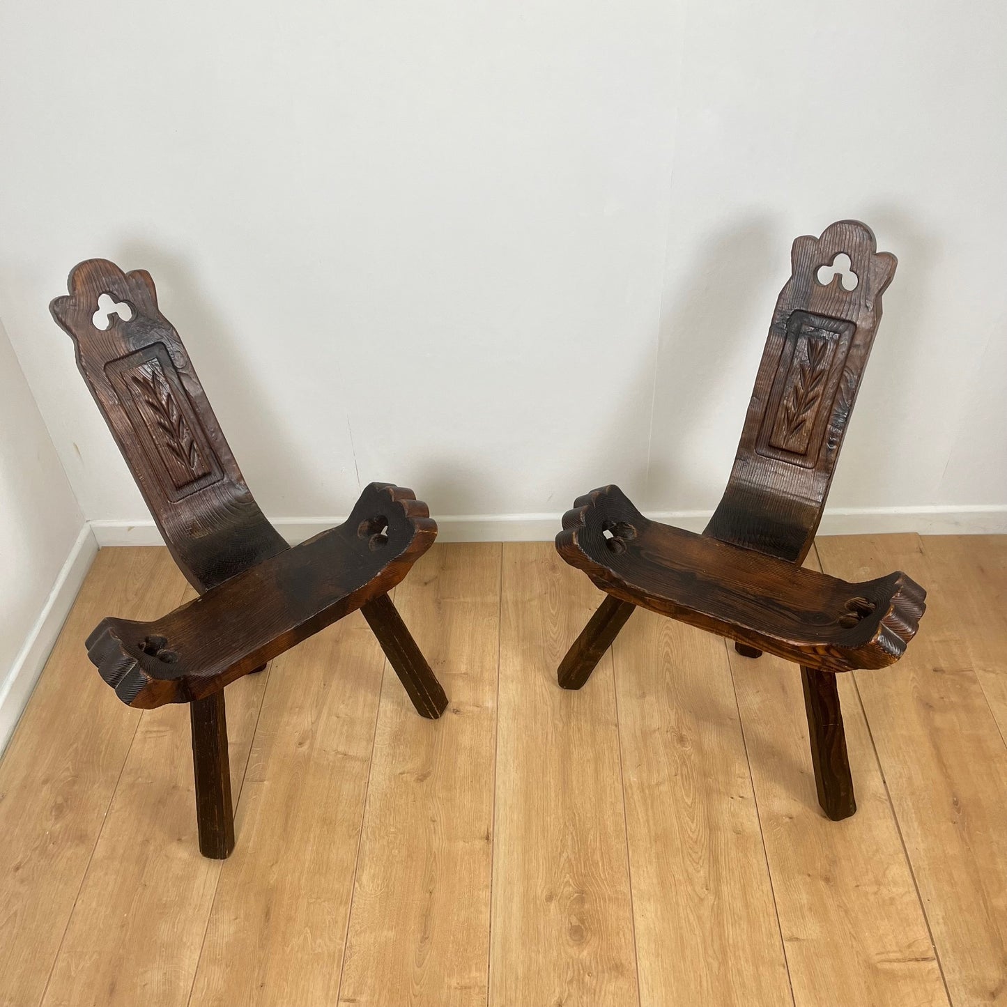 Pair of brutalist tripod low chairs in solid wood, mid-20th century.