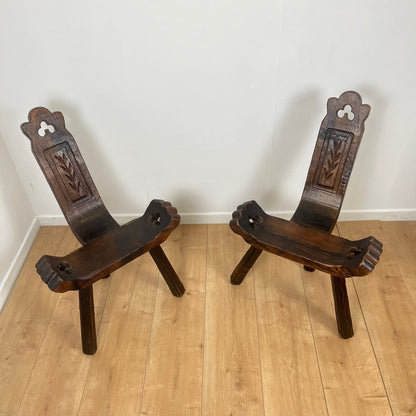 Pair of brutalist tripod low chairs in solid wood, mid-20th century.