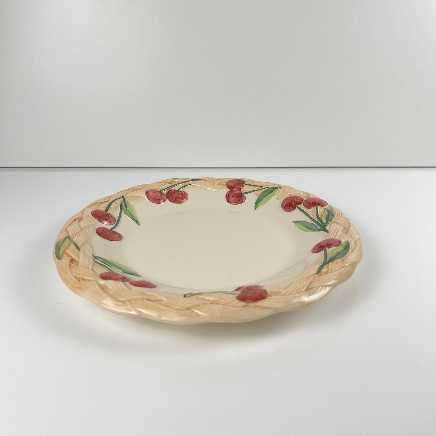 Antique earthenware dish with cherry pattern, signed "FG", 20th century