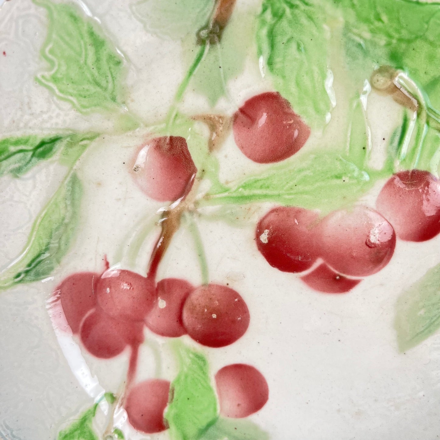 Set of 4 KG St Clément barbotine fruit plates (cherry, mirabelle plum, grape, pear), late 19th-early 20th century