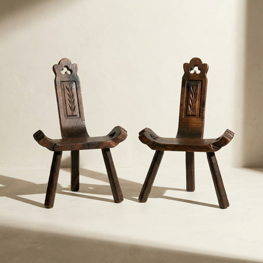 Paire de chaise basse tripode brutalise en bois massif , milieu XXe s.